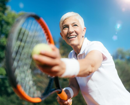 A woman holding onto a tennis racket and hitting the ball.
