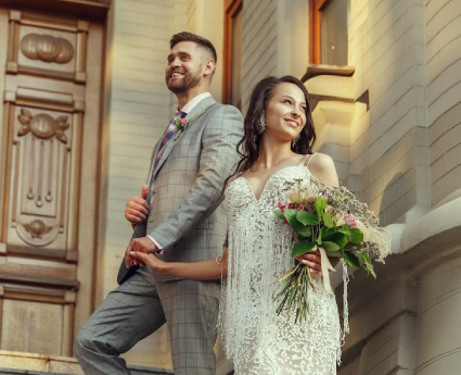 A man and woman holding hands while standing on steps.