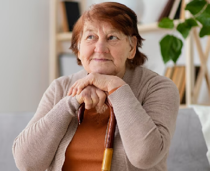 A woman with her hands on the handle of an umbrella.